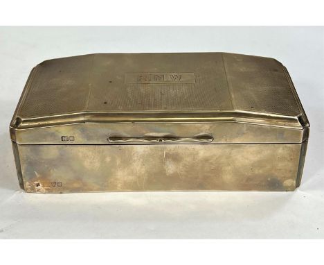 A hallmarked silver cigarette box, engine turned with hinged lid and weighted base, monogrammed, Chester 1929, length 18 cm 