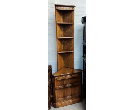 A modern Ercol medium elm full height corner cupboard with open shelves over panelled cupboard 