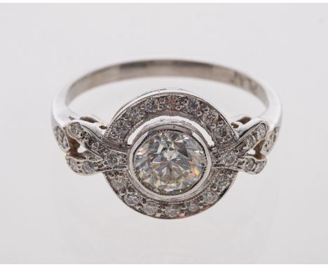 A platinum ring set with a central diamond estimated at 0.70 carat, diamond set halo and shoulders, ring size M-N     Conditi