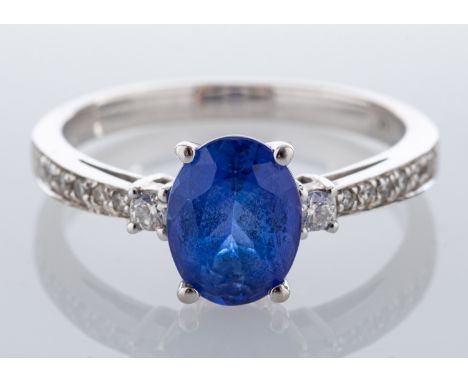 A tanzanite and diamond ring, the oval cut tanzanite claw set between brilliant cut diamond set shoulders, stamped 14K, ring 