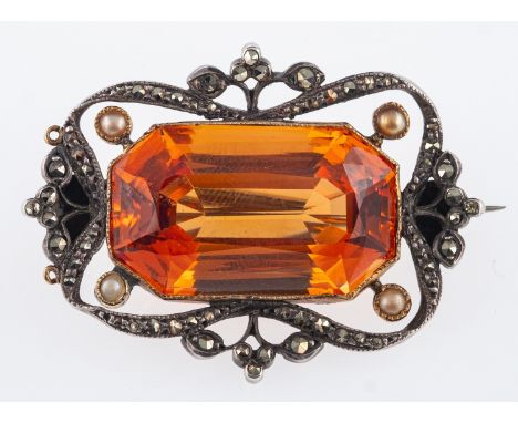 An Edwardian brooch set with a step cut orange topaz stone, in white metal mount with seed pearls and marcasite,and topaz   