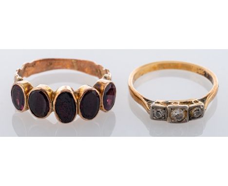 A three stone diamond ring, claw and millegrain set with three brilliant cut diamonds; and a 19th Century five stone garnet r