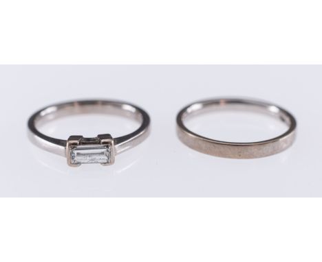 A white gold ring set with a baguette form diamond, in 18ct, hallmark for Edinburgh 2005 and a matching wedding band, ring si
