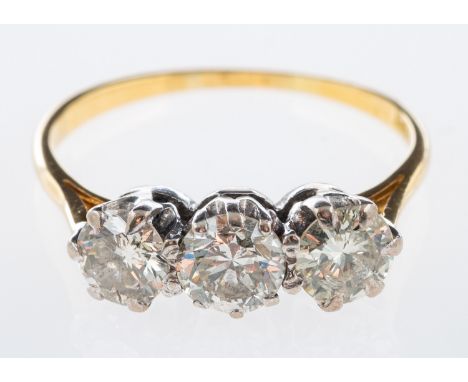 A three stone diamond ring set with brilliant cut diamonds in 18ct white and yellow gold, total diamond weight in excess of 1