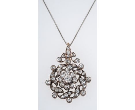 An antique diamond pendant C1910, the central floral setting with a diamond of 0.33 carats, silver and gold setting, total di