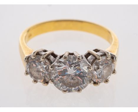 An 18ct gold diamond three stone ring, the central brilliant cut diamond, estimated to weigh 1.90 carats, claw set between tw