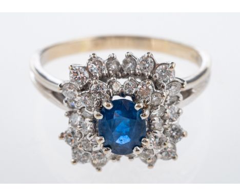 A sapphire and diamond cluster dress ring, central mid blue sapphire, 7 x 5 mm, within an informal border of small diamonds, 