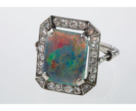 An Art Deco style opal and diamond plaque ring, good quality opal showing all colours, within a border of brilliant cut diamo