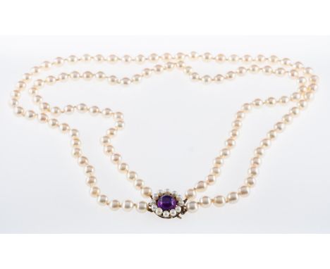  A cultured pearl necklace of two rows,strung to a silver clasp set with a cabouchon amethyst., pearls cream with peach overt