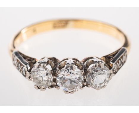 A diamond three stone ring, the three brilliant cut diamonds, approximately 0.55 carats total, with eight cut diamonds set to