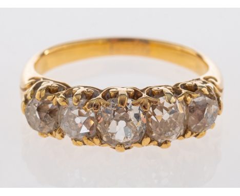 A fine Victorian five stone ring, old cut diamonds in carved mount with small fleur de lys emblems, unmarked, assessed as 18c