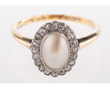 An Edwardian mabe pearl and diamond ring, the oval pearl millgrain set within a border of old cut diamonds, unmarked yellow m