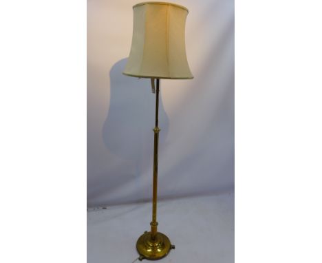 A brass standard lamp in the classical taste raised on circular base and three scroll feet H 145cm 