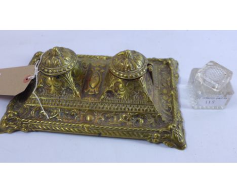 An early 20th century embossed brass ink stand together with a glass inkwell 