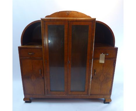 An Art Deco burr walnut display cabinet with two glazed doors flanked by two single drawers above two cupboard doors raised o
