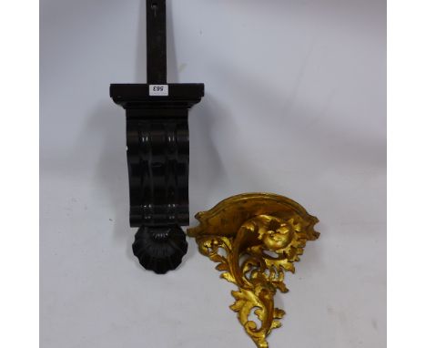 A carved gilt wood wall bracket together with a black painted plaster wall bracket 