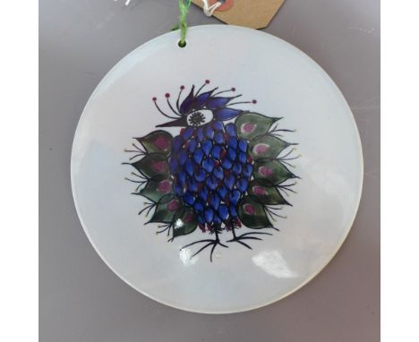 A Royal Copenhagen circular ceramic wall plaque decorated with a peacock. stamped with three wavy lines and makers initial 'L