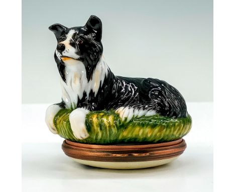A trinket box that depicts a black and white border collie sitting on a field of grass with the bottom half containing the li