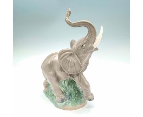 Depicts an elephant with its trunk raised. Glossy finish; Nao by Lladro backstamp. Dimensions: 6"L x 3.25"W x 9"HManufacturer