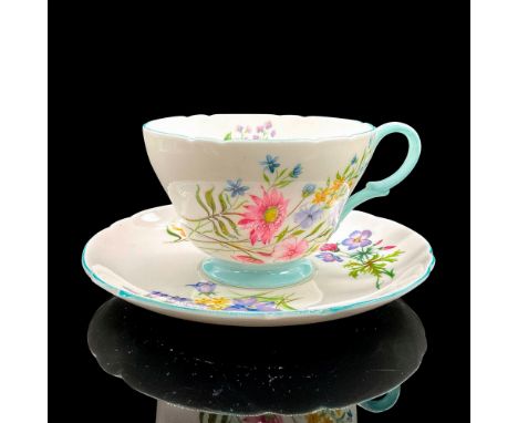 Vintage white bone china with dainty colorful flowers, blue rims. Henley shape. Tea cup 4"L x 3.5"W x 2.5"H. Saucer 0.75"H x 