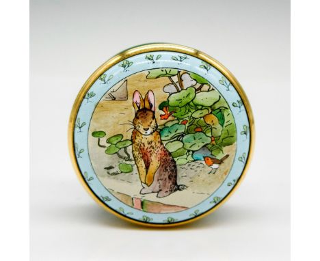 Hand painted enamel box with gilded edge screw top displaying Peter rabbit in a meadow. Halcyon Days backstamp. This item has