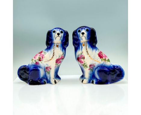 A set of two ceramic dog figurines that are painted in a white and blue gradient with floral patterns on their bodies. Made i