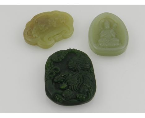A Chinese jade pendant, together with a green hardstone pendant, and a jade pendant carved with a Buddha. (3)