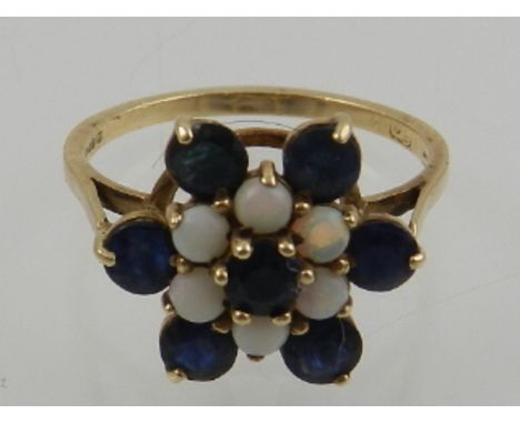 A 9 carat yellow gold opal and sapphire dress ring, fashioned as a flower head.
