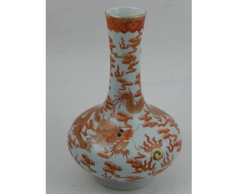 A Chinese squat baluster porcelain vase, decorated in iron red and gilt with dragon chasing flaming pearl amongst stylised cl