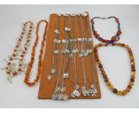 A quantity of jewellery, to include two amber necklaces, two coral necklaces, and various silver pendants and chains depictin