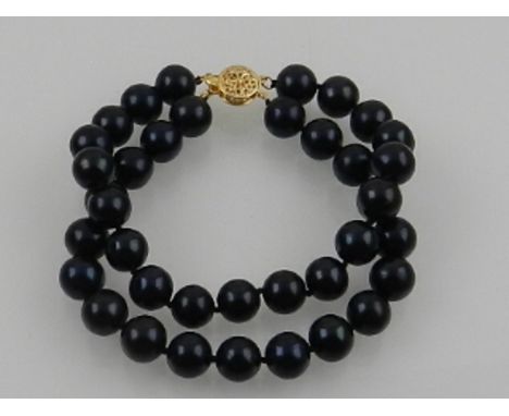 A double strand South Sea black pearl bracelet, with a 14 carat yellow gold clasp. 