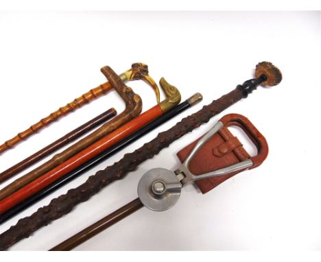 A 'THURTON' FOLDING SHOOTING STICK and six assorted sticks to include one with brass dog head grip and an ebonised cane with 