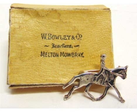 A SILVER BROOCH OF A DRESSAGE HORSE AND RIDER marked 925, length 3.5cm