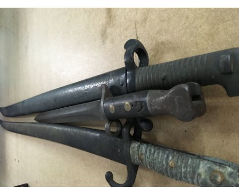 Two long sword bayonet with scabbard and one other .