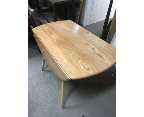 A blonde Ercol drop leaf dining table