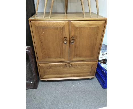 A blonde Ercol TV cabinet.