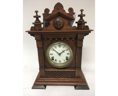 A Continental walnut mantel clock with a shaped pediment.