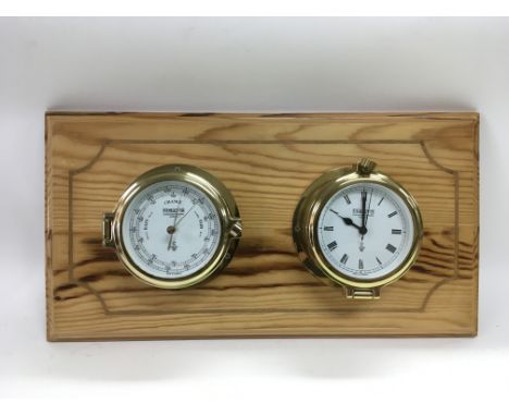 A Wempe brass cased barometer and clock set mounted on a wooden plaque, clock not working,