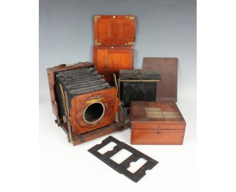 A Houghton &amp; Son mahogany and brass folding plate camera with black leather bellows, the brass adjustment arms detailed '