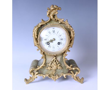 A late 19th century French gilt metal mounted onyx mantel clock with eight day movement striking on a bell, the enamelled dia