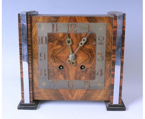 An Art Deco walnut mantel clock with eight day Empire movement striking on a gong, the square brass chapter ring with pierced
