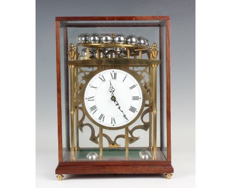 A late 20th century brass spherical weight clock timepiece, the circular dial with black Roman hour numerals, with platform e