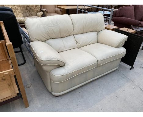 A CREAM LEATHER TWO SEATER SOFA 