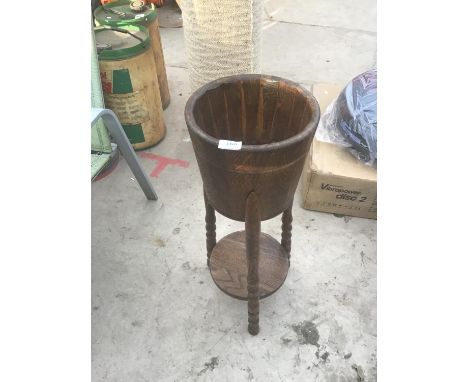 AN OAK TRIPOD LEG PLANT STAND WITH LOWER SHELF 