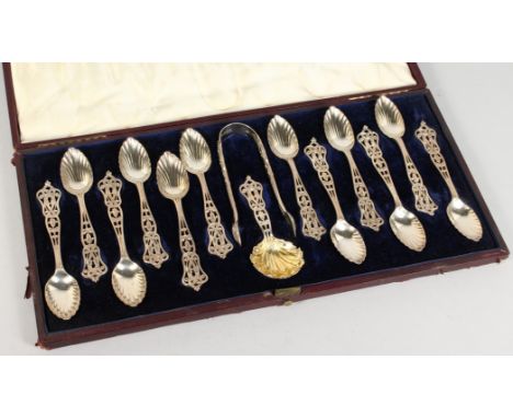 A SUPERB SET OF TWELVE VICTORIAN PIERCED SILVER TEASPOONS, TONGS AND CADDY SPOON in a case. London 1855. Maker F. H.