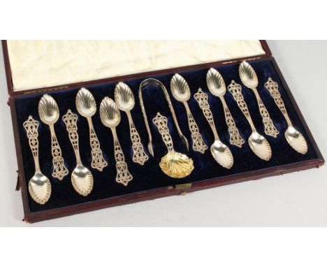 A SUPERB SET OF TWELVE VICTORIAN PIERCED SILVER TEASPOONS, TONGS AND CADDY SPOON in a case. London 1855. Maker F. H.