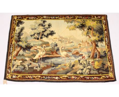 A CONTINENTAL TAPESTRY WALL HANGING with a wooded river landscape, classical ruins and birds. 5ft 0ins long x 3ft 6ins high.