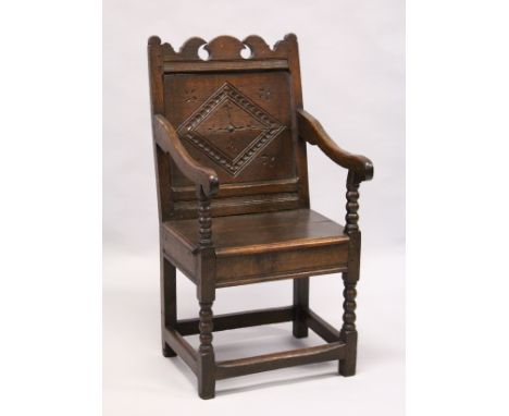 A 17TH CENTURY OAK WAINSCOTT CHAIR, with shaped cresting rail, carved back panel, the solid seat on bobbin turned and stretch