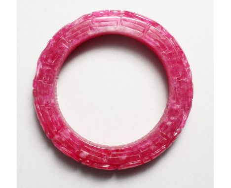 A CHINESE CARVED PINK JADE BANGLE. 3.25ins diameter.