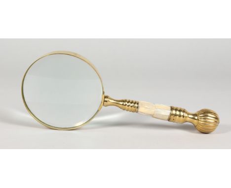 A LARGE MAGNIFYING GLASS with brass and mother-of-pearl handle.